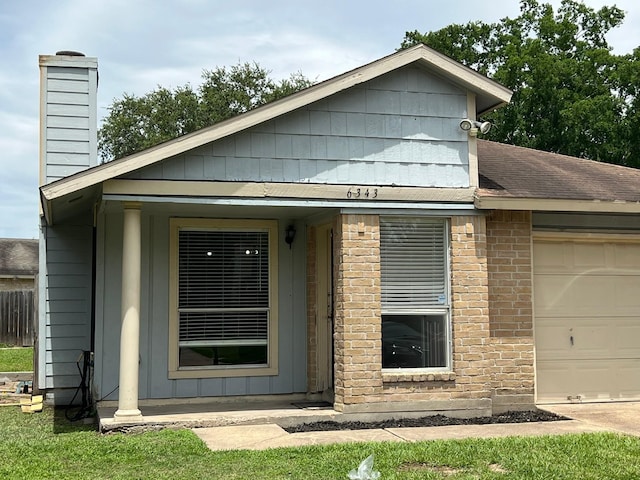 6343 Glenhagen Dr, Houston, TX 77084 - view of front facade with a chimney, an attached garage, brick siding, and a shingled roof