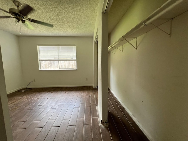6343 Glenhagen Dr, Houston, TX 77084 - unfurnished bedroom with dark wood-style flooring, baseboards, ceiling fan, and a textured ceiling
