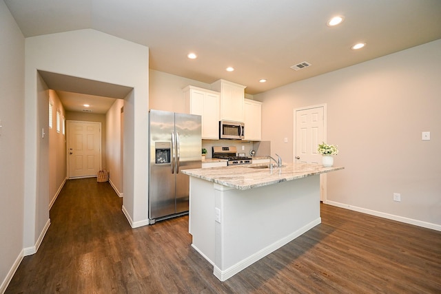 10130 Barn Owl Trl, Magnolia, TX 77354 - kitchen with appliances with stainless steel finishes, dark wood-style flooring, a center island with sink, white cabinetry, and baseboards