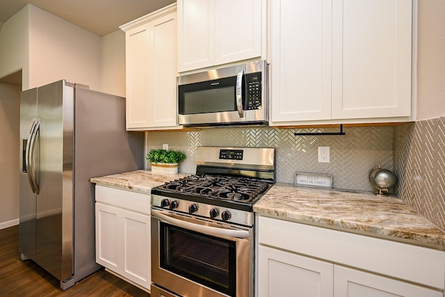 10130 Barn Owl Trl, Magnolia, TX 77354 - kitchen featuring stainless steel appliances, dark wood-style floors, decorative backsplash, white cabinetry, and light stone countertops