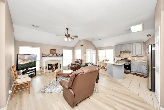 11843 Leaf Oak Dr, Houston, TX 77065 - living room with vaulted ceiling, light wood-style flooring, ceiling fan, and a tile fireplace