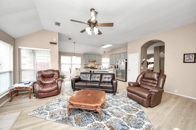 11843 Leaf Oak Dr, Houston, TX 77065 - living area with vaulted ceiling, ceiling fan, arched walkways, light wood-style floors, and baseboards