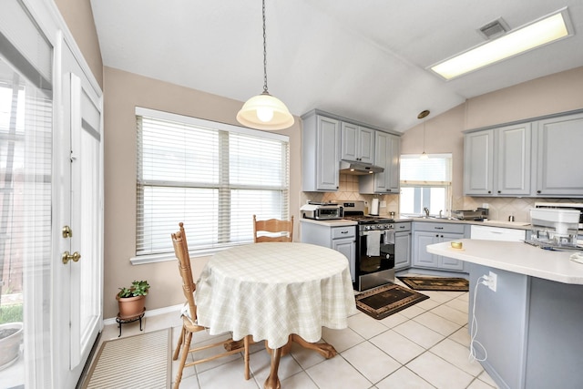 11843 Leaf Oak Dr, Houston, TX 77065 - kitchen featuring gray cabinetry, stainless steel range with gas cooktop, under cabinet range hood, vaulted ceiling, and tasteful backsplash
