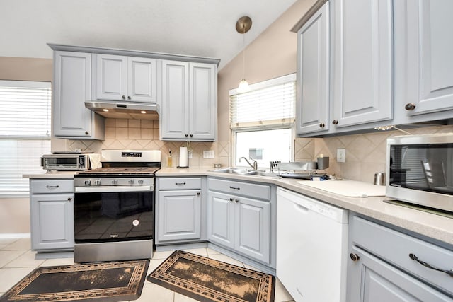 11843 Leaf Oak Dr, Houston, TX 77065 - kitchen with appliances with stainless steel finishes, a sink, under cabinet range hood, and decorative backsplash