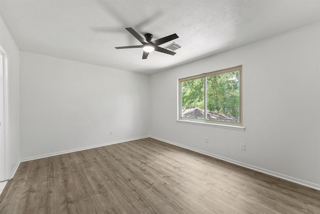 563 Roanoke Dr, Conroe, TX 77302 - empty room featuring wood finished floors, ceiling fan, baseboards, and a textured ceiling
