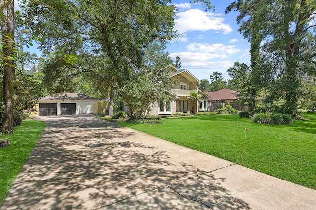 563 Roanoke Dr, Conroe, TX 77302 - view of front facade featuring a detached garage, a front lawn, driveway, and brick siding