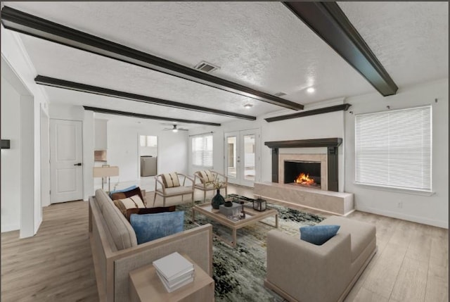 563 Roanoke Dr, Conroe, TX 77302 - living room with a textured ceiling, wood finished floors, beamed ceiling, a high end fireplace, and baseboards