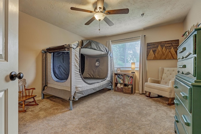bedroom with light colored carpet, a textured ceiling, ceiling fan, and baseboards