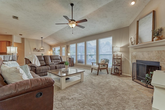 living area with lofted ceiling, a textured ceiling, a ceiling fan, a fireplace, and baseboards