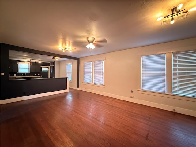544 W 28th St, Houston, TX 77008 - unfurnished living room featuring dark wood-type flooring, baseboards, and ceiling fan