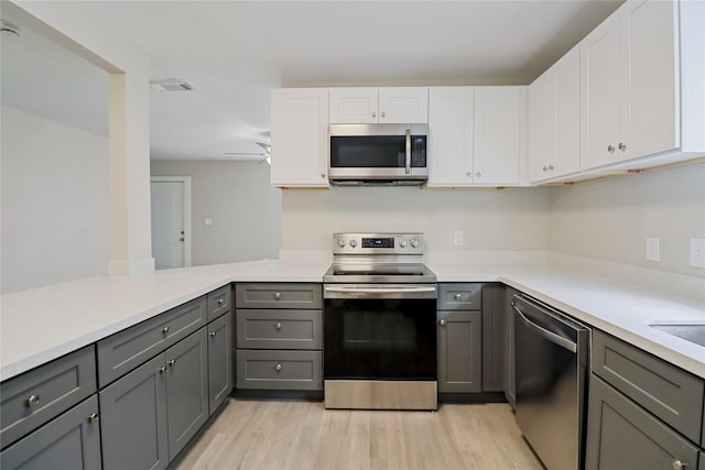 1306 W 6th St, Freeport, TX 77541 - kitchen with appliances with stainless steel finishes, gray cabinets, light wood-style flooring, and light countertops