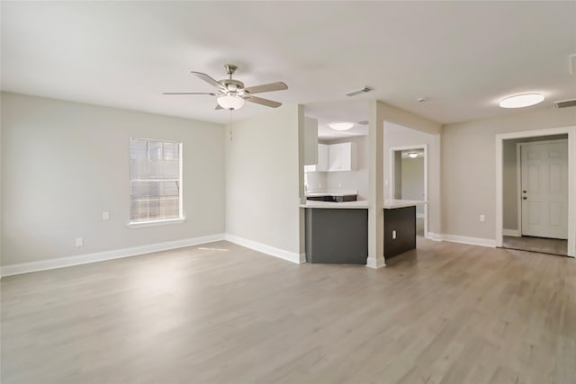 1306 W 6th St, Freeport, TX 77541 - unfurnished living room with light wood-style floors, a ceiling fan, and baseboards