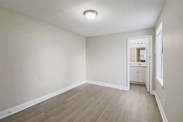 1306 W 6th St, Freeport, TX 77541 - spare room featuring light wood-style flooring and baseboards