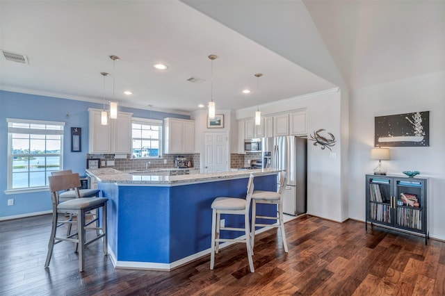 2101 Menard Ave, Seabrook, TX 77586 - kitchen with stainless steel appliances, a breakfast bar, dark wood-style floors, crown molding, and recessed lighting