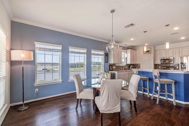 2101 Menard Ave, Seabrook, TX 77586 - dining area featuring dark wood-type flooring, ornamental molding, recessed lighting, a water view, and baseboards