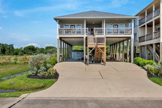 2101 Menard Ave, Seabrook, TX 77586 - view of front of home with a carport, stairway, concrete driveway, and a shingled roof
