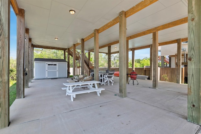 2101 Menard Ave, Seabrook, TX 77586 - view of patio featuring a storage shed, an outdoor structure, fence, outdoor dining space, and stairs