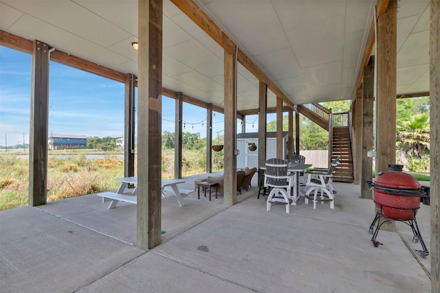 2101 Menard Ave, Seabrook, TX 77586 - view of patio / terrace featuring stairway, a storage unit, an outbuilding, outdoor dining space, and a water view
