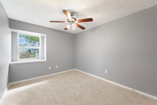 carpeted spare room with a ceiling fan, a textured ceiling, and baseboards