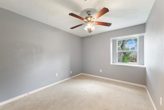 empty room featuring light carpet, baseboards, and a ceiling fan