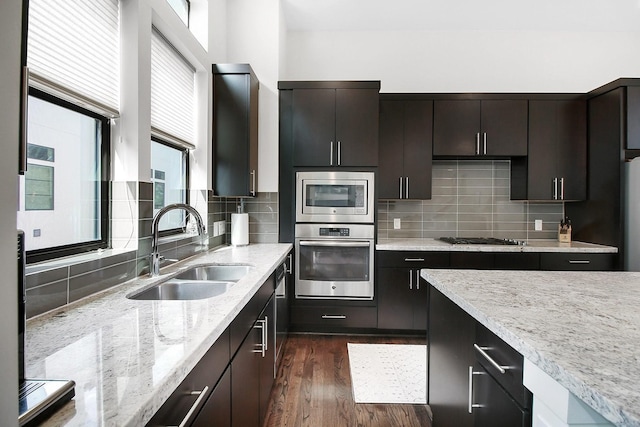 2205 Colorado St, Houston, TX 77007 - kitchen with appliances with stainless steel finishes, a sink, light stone countertops, dark wood-type flooring, and tasteful backsplash