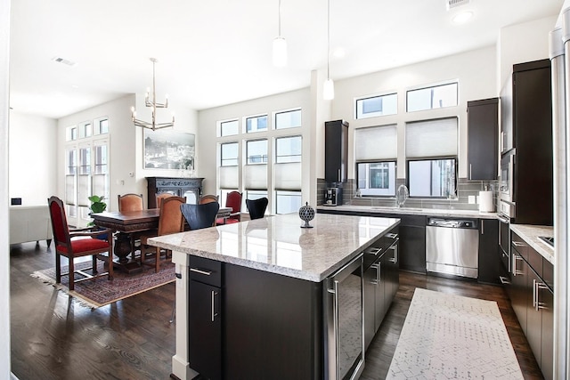 2205 Colorado St, Houston, TX 77007 - kitchen featuring appliances with stainless steel finishes, a center island, dark wood finished floors, wine cooler, and recessed lighting