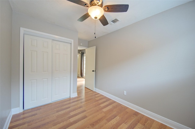 unfurnished bedroom with light wood-style floors, baseboards, a closet, and ceiling fan