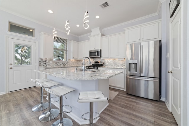 29122 Artic Brook Ln, Fulshear, TX 77441 - kitchen featuring appliances with stainless steel finishes, tasteful backsplash, a sink, white cabinets, and a center island with sink
