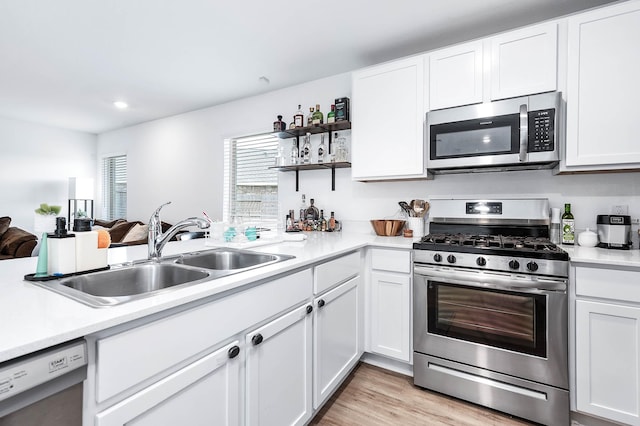 9927 Archdale Spring Dr, Baytown, TX 77521 - kitchen with stainless steel appliances, a sink, light countertops, open shelves, and white cabinetry