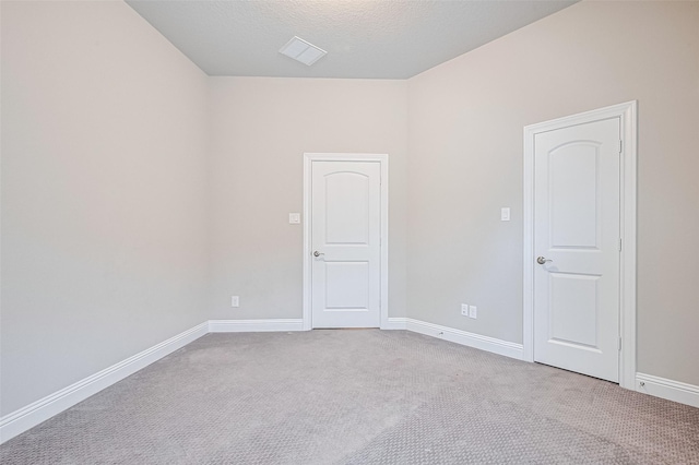 carpeted spare room featuring baseboards and a textured ceiling
