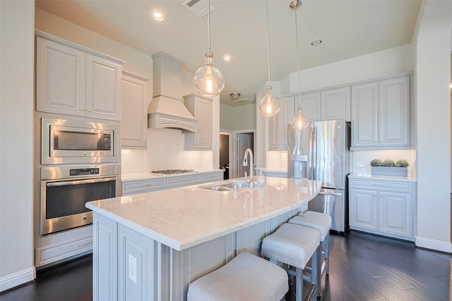 kitchen featuring appliances with stainless steel finishes, a sink, custom range hood, dark wood-style floors, and recessed lighting