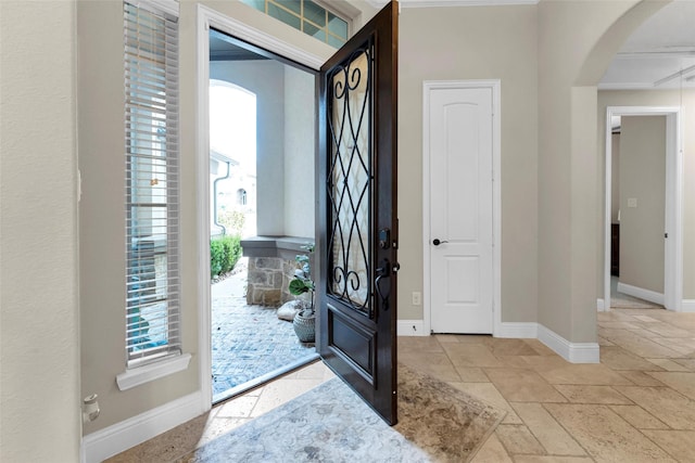 222 Reynosa Ct, Pinehurst, TX 77362 - foyer with arched walkways, stone tile floors, and baseboards
