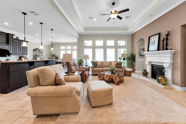 222 Reynosa Ct, Pinehurst, TX 77362 - living room featuring ceiling fan, crown molding, a glass covered fireplace, arched walkways, and recessed lighting