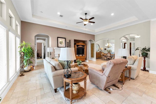222 Reynosa Ct, Pinehurst, TX 77362 - living area with a raised ceiling, stone tile floors, plenty of natural light, recessed lighting, and ornamental molding