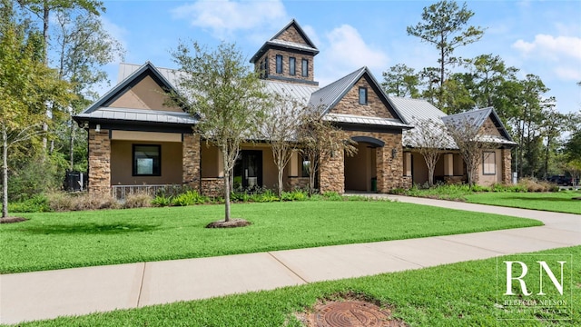 222 Reynosa Ct, Pinehurst, TX 77362 - view of front of home featuring a standing seam roof, a front lawn, stone siding, covered porch, and metal roof