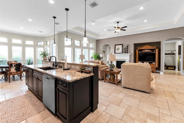 222 Reynosa Ct, Pinehurst, TX 77362 - kitchen with stainless steel dishwasher, arched walkways, a sink, stone tile flooring, and recessed lighting