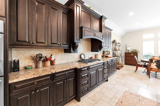 222 Reynosa Ct, Pinehurst, TX 77362 - kitchen featuring stainless steel gas stovetop, tasteful backsplash, stone tile floors, light stone countertops, and vaulted ceiling