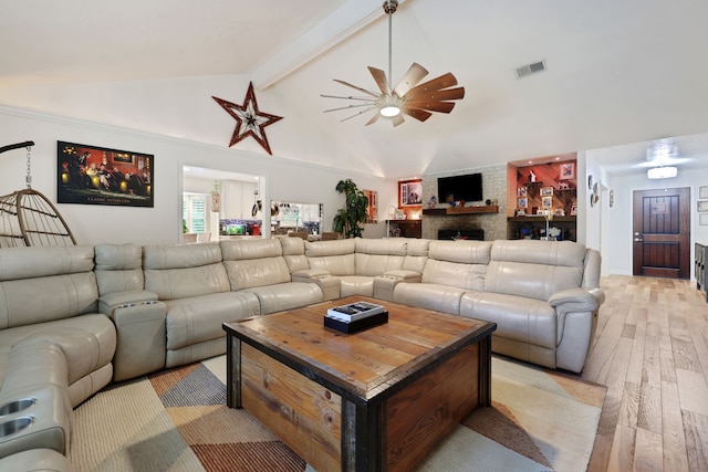 6206 Bayou Blvd, Baytown, TX 77521 - living area with light wood finished floors, ceiling fan, a large fireplace, beam ceiling, and high vaulted ceiling