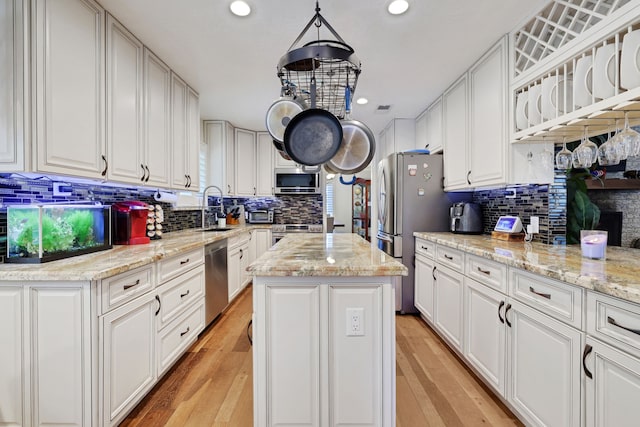 6206 Bayou Blvd, Baytown, TX 77521 - kitchen featuring appliances with stainless steel finishes, a sink, a kitchen island, backsplash, and recessed lighting