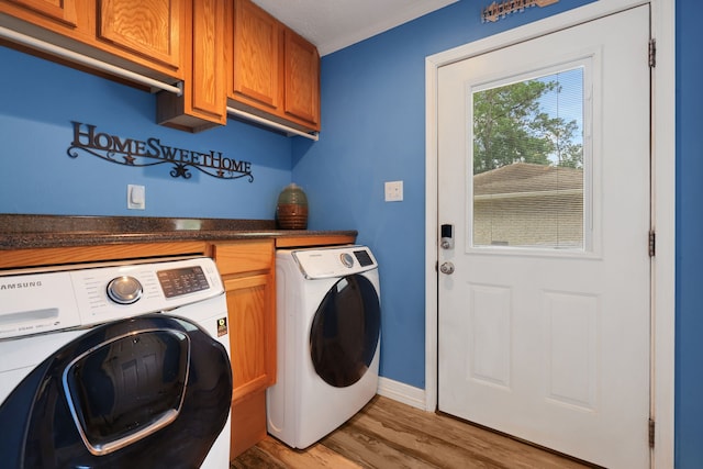 6206 Bayou Blvd, Baytown, TX 77521 - clothes washing area featuring independent washer and dryer, cabinet space, light wood-style flooring, and baseboards