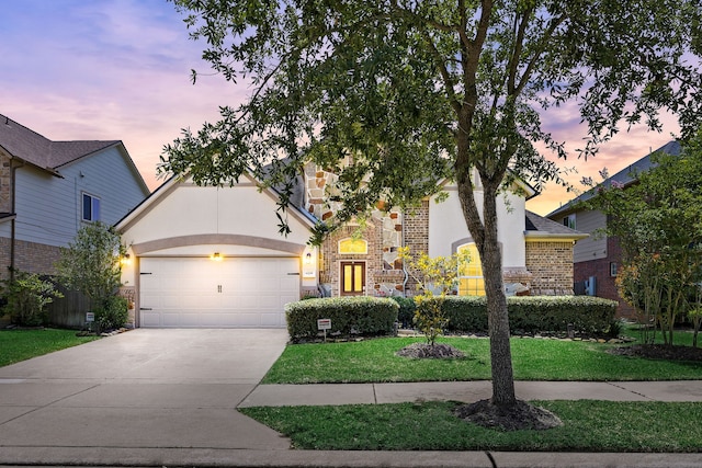 6230 Ledger Ln, Missouri City, TX 77459 - view of front of home featuring a garage, driveway, stucco siding, brick siding, and a front lawn