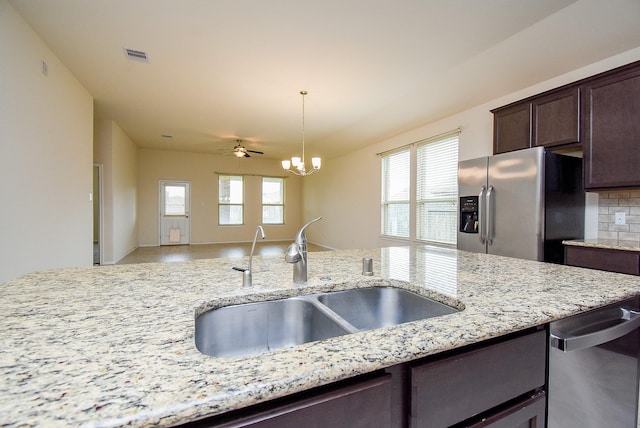 4622 Stolz Trl, Katy, TX 77493 - kitchen with appliances with stainless steel finishes, a sink, dark brown cabinets, and plenty of natural light