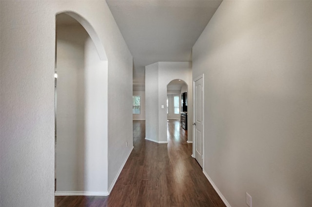 9533 E Woodmark, Conroe, TX 77304 - hall with arched walkways, dark wood-style flooring, and baseboards