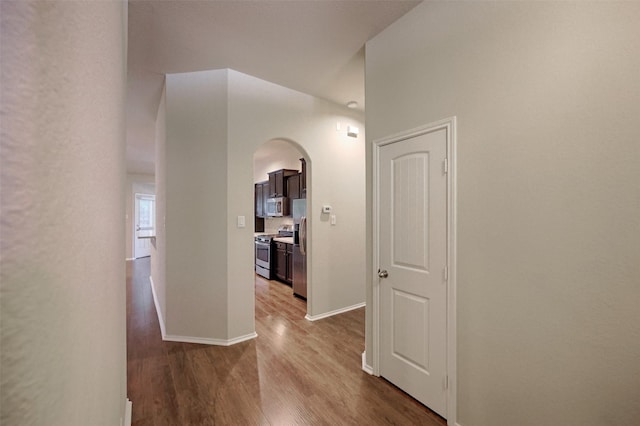 9533 E Woodmark, Conroe, TX 77304 - hall with arched walkways, dark wood-type flooring, and baseboards