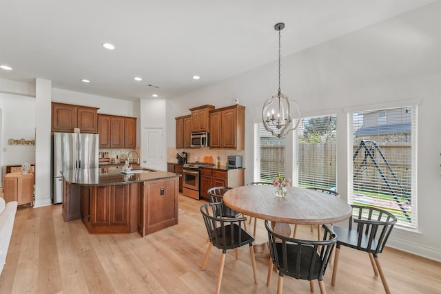 28803 Crested Butte Dr, Katy, TX 77494 - kitchen with appliances with stainless steel finishes, a chandelier, a sink, backsplash, and a center island with sink