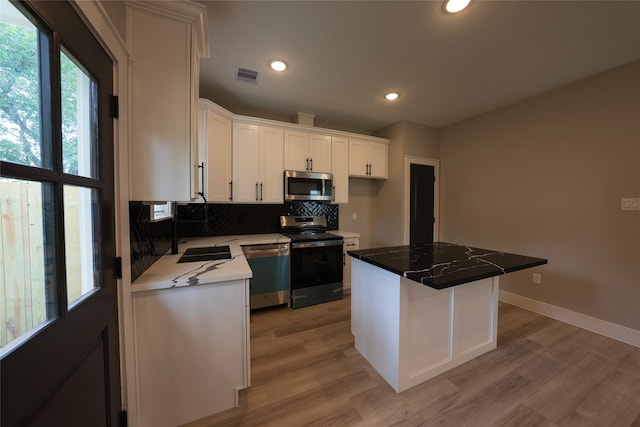 kitchen with stainless steel appliances, light wood-style flooring, decorative backsplash, white cabinets, and recessed lighting