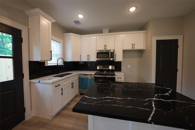 kitchen featuring stainless steel appliances, a sink, white cabinets, and recessed lighting