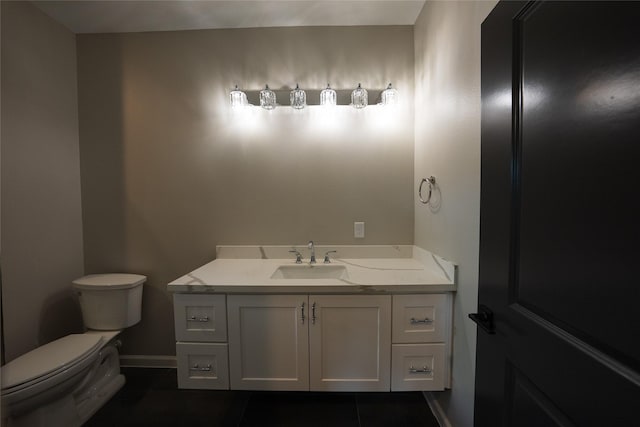 half bath with toilet, tile patterned flooring, vanity, and baseboards