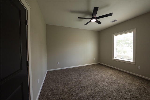 carpeted spare room featuring a ceiling fan and baseboards