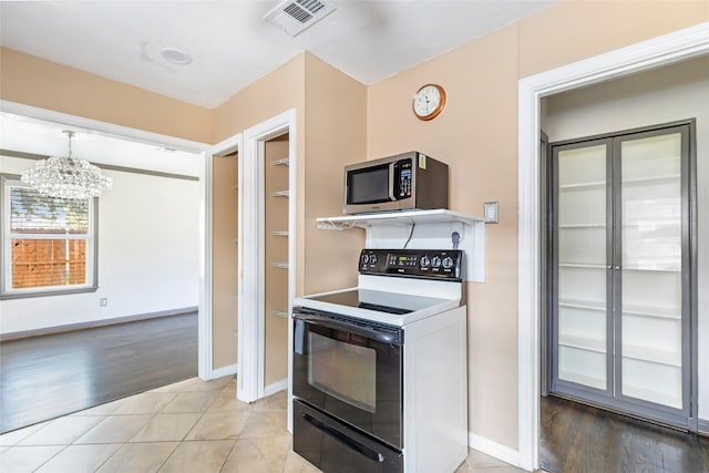 1741 Gardenia Dr, Houston, TX 77018 - kitchen featuring electric range oven, stainless steel microwave, a chandelier, and baseboards